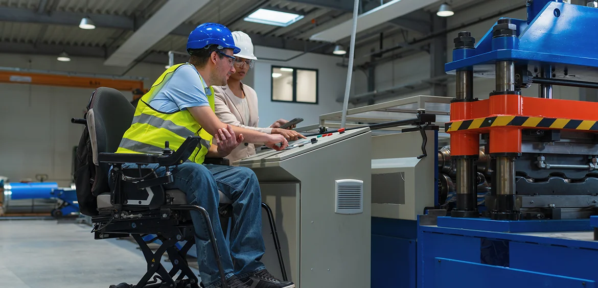 Man in veiligheidskleding in rolstoel aan het werk