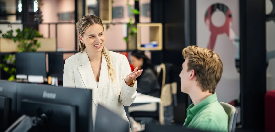 Twee medewerkers van Flexhub met elkaar in gesprek op kantoor over salaris, HR of loontransparantie.