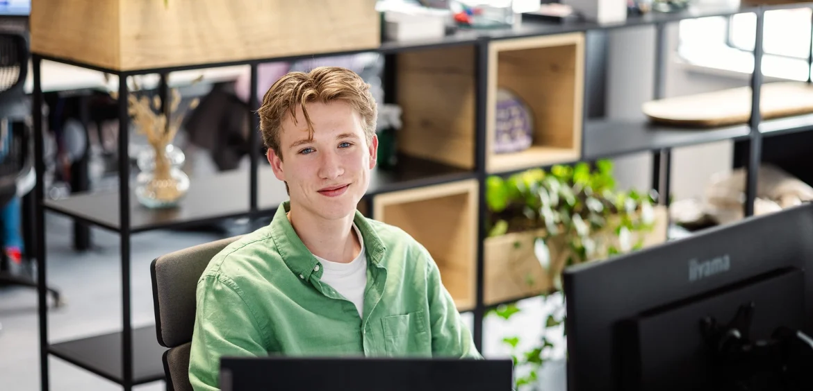 Jonge medewerker aan het werk op kantoor bij Flexhub, bij een artikel over de aanvullende cao-afspraken voor uitzendkrachten in 2027.